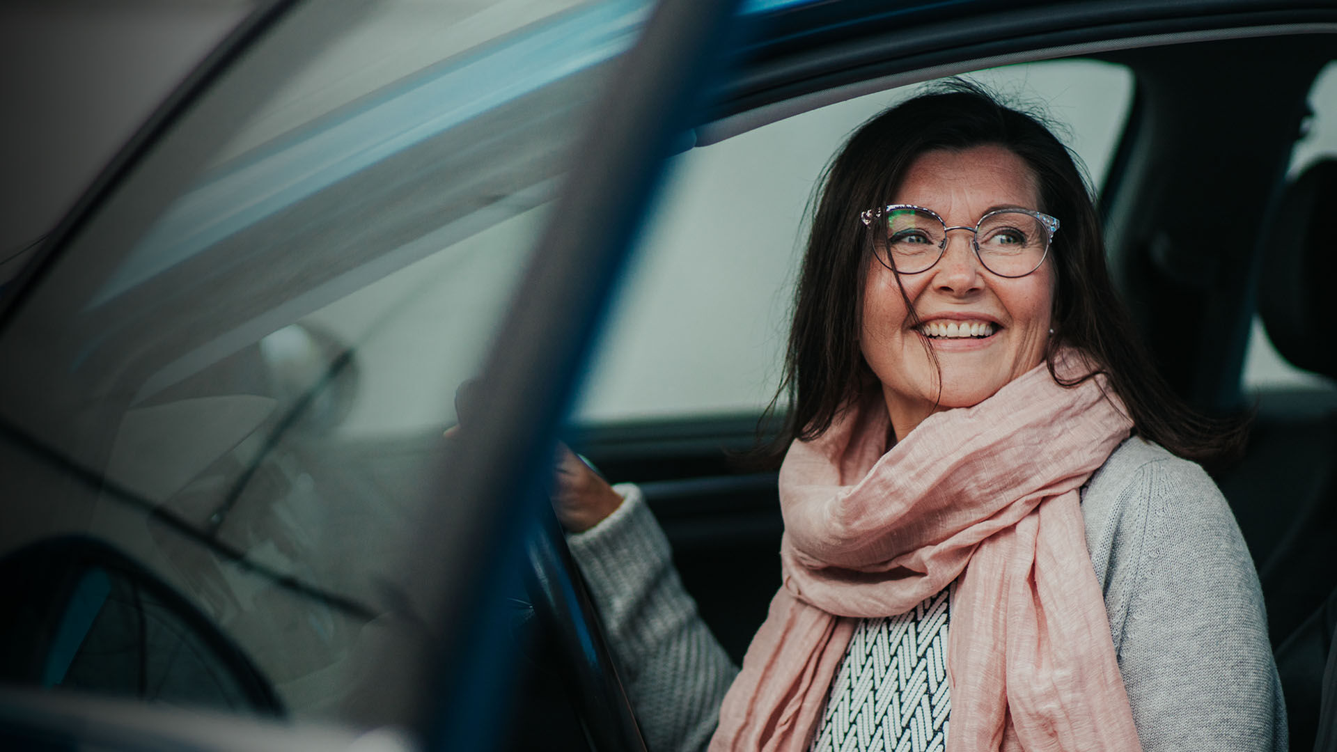 Hymyilevä nainen autonratissa